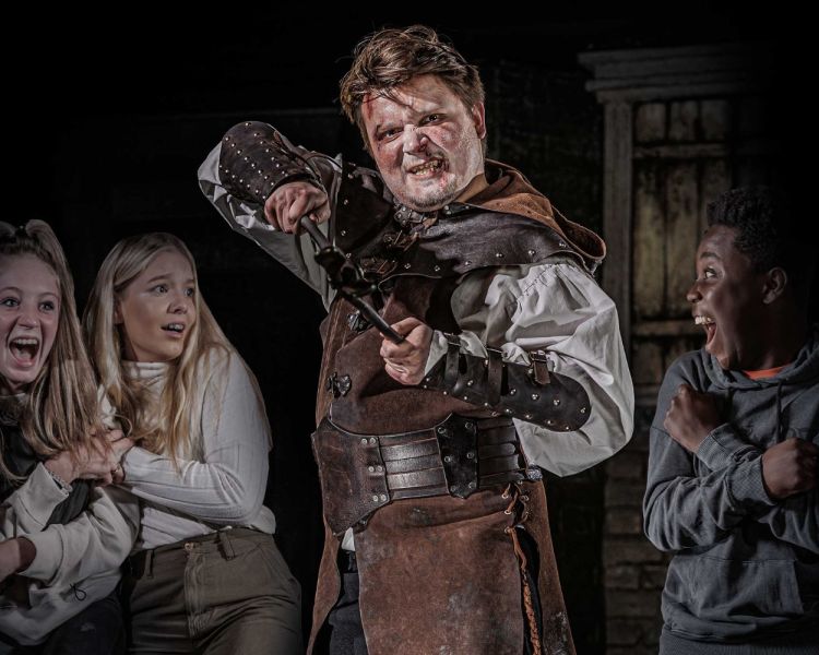 Torturer with guests at london dungeon