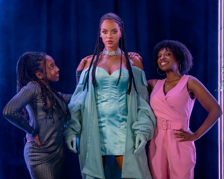 girls standing next to rhianna at madame tussauds london