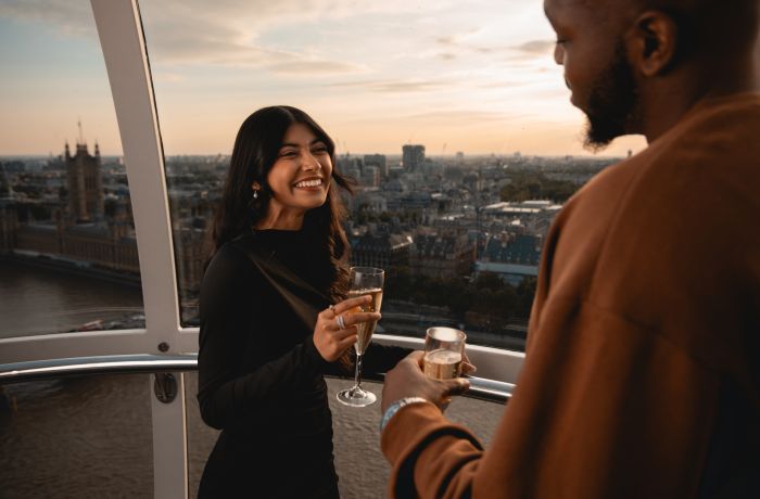 couple on the london eye at sunset drinking champagne