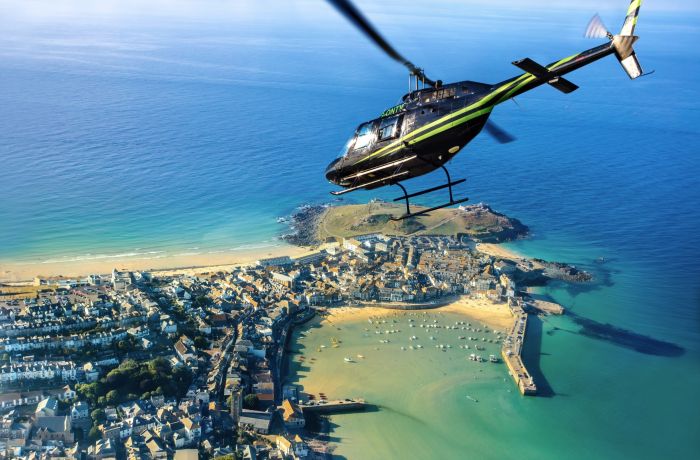 helicopter flying over the cornish coastline