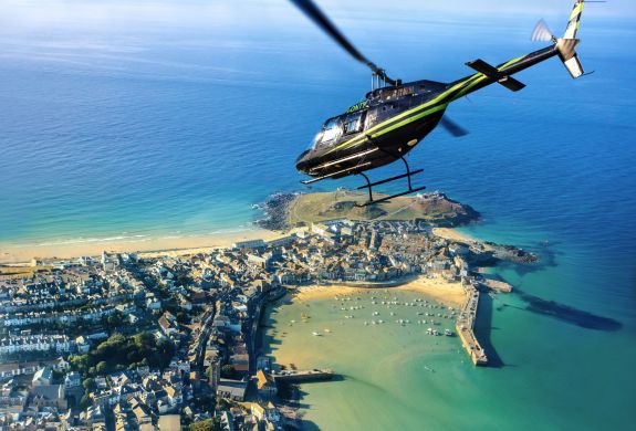 helicopter flying over the cornish coastline