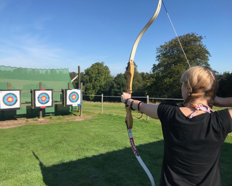 Girl aiming at target on archery experience