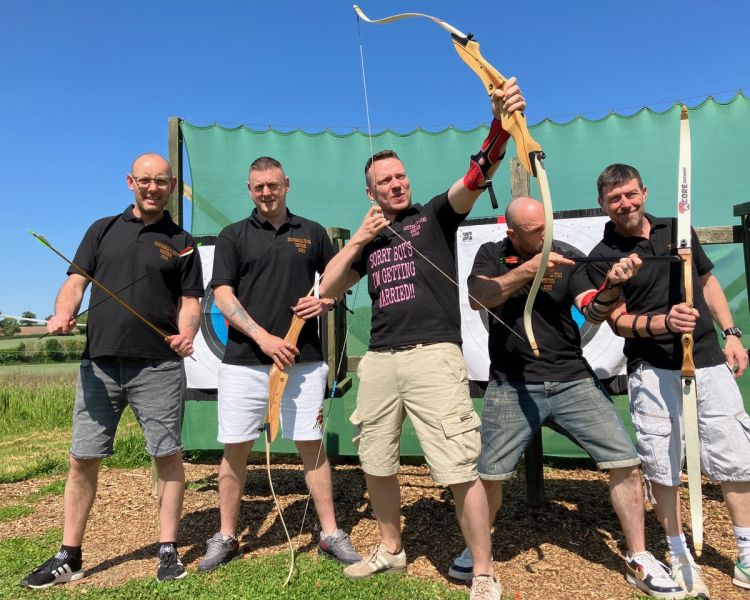 Group posing with bows on archery experience