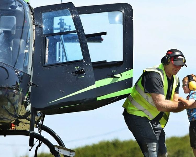 man helping a young child into a helicopter for a nottingham helicopter ride