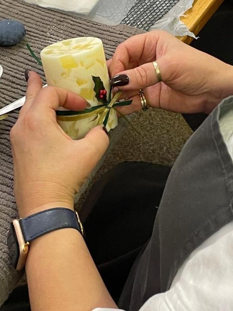 Decorating candle with ribbon at candle making workshop