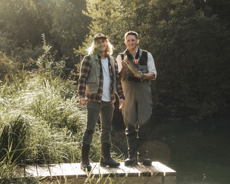 two men next to river on fishing trip