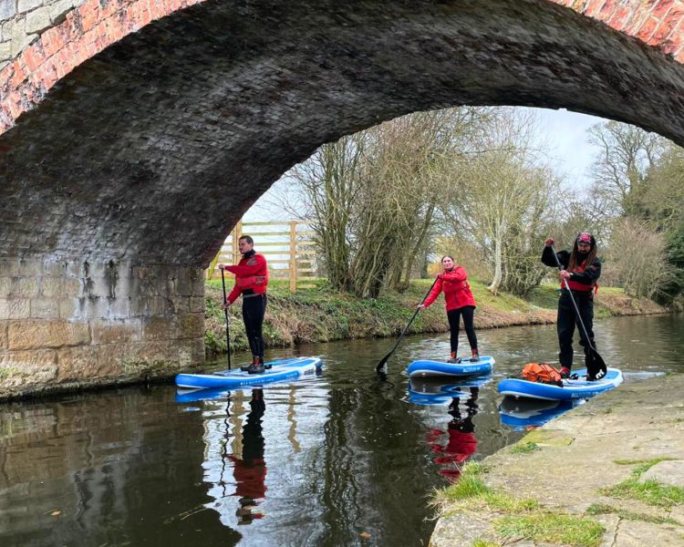 Man and woman with instructor sup boarding