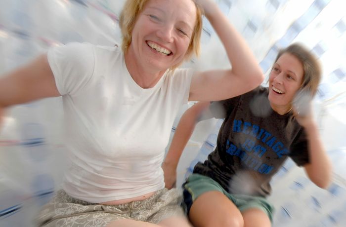 two women laughing inside an aqua sphere on an aqua sphereing experience day