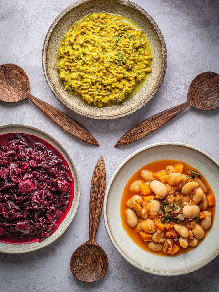 a trio of healthy meals on a table with wooden spoons