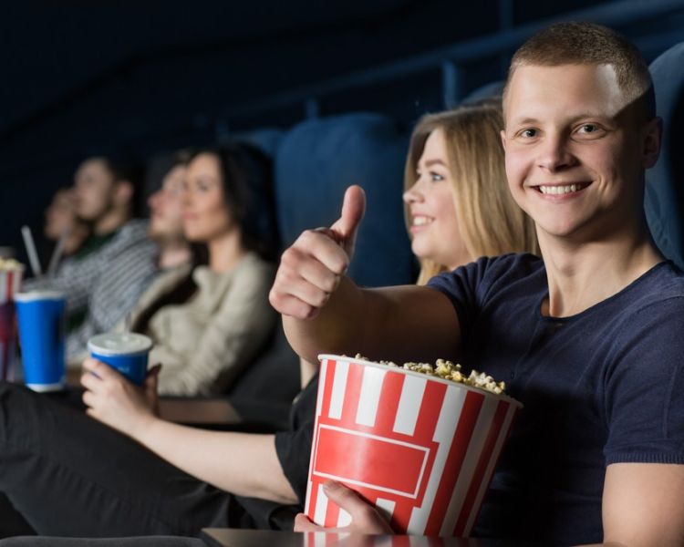cinema audience watching film and man giving thumbs up