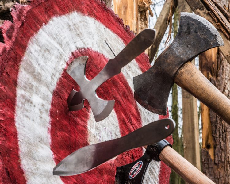 Axes and knife in wooden block target