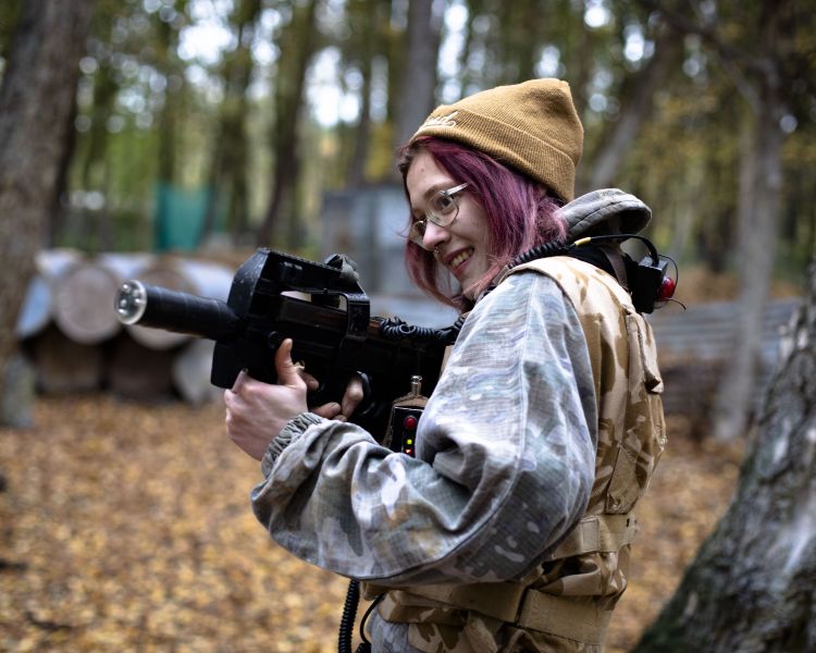 woman on outdoor laser combat experience in woodland