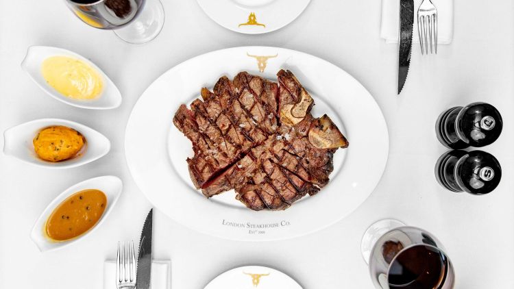 steak on a white plate with sauces on the side served at marco pierre white's london steakhouse