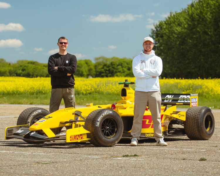 father and son standing next to f1 jordan ej12
