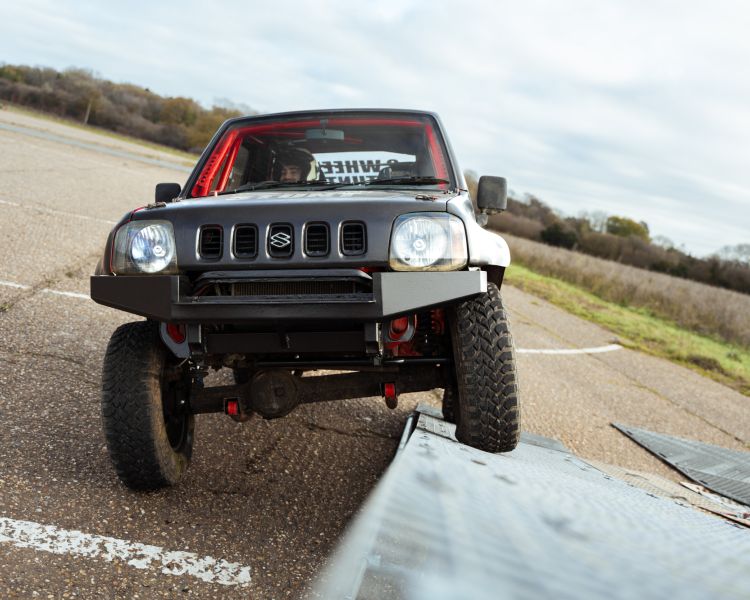 stunt car being driven up a ramp on two wheels on a stunt driving experience