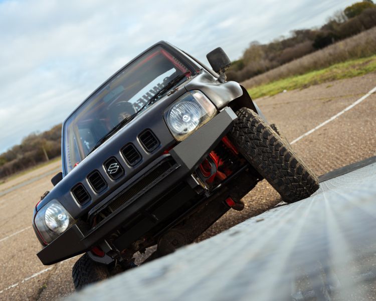 stunt car being driven up a ramp on two wheels on a stunt driving experience
