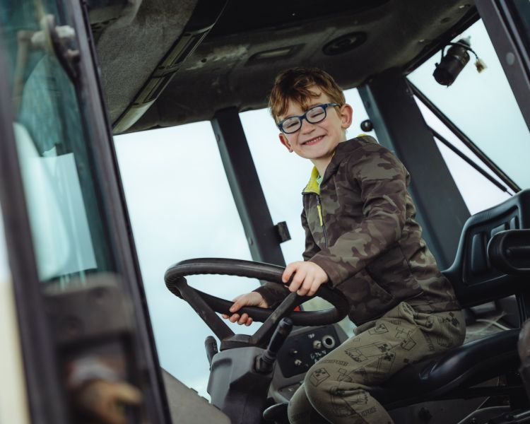 boy sitting in cab of a lamborghini tractor on a tractor driving experience