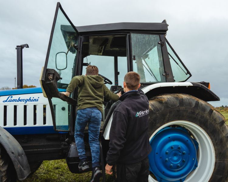 boy climbing into a lamborghini tractor on a tractor driving experience
