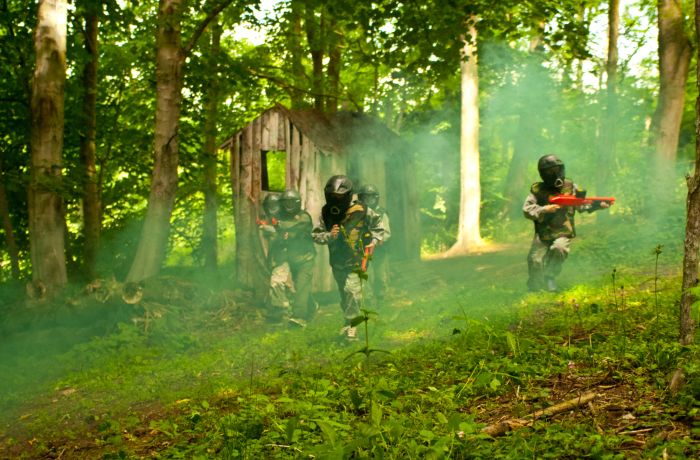 kids playing paintball in forest