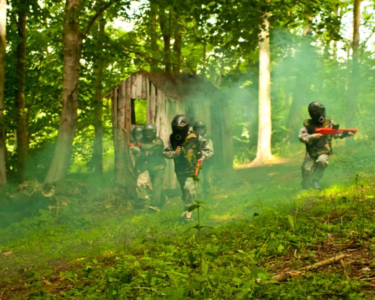kids playing paintball in forest