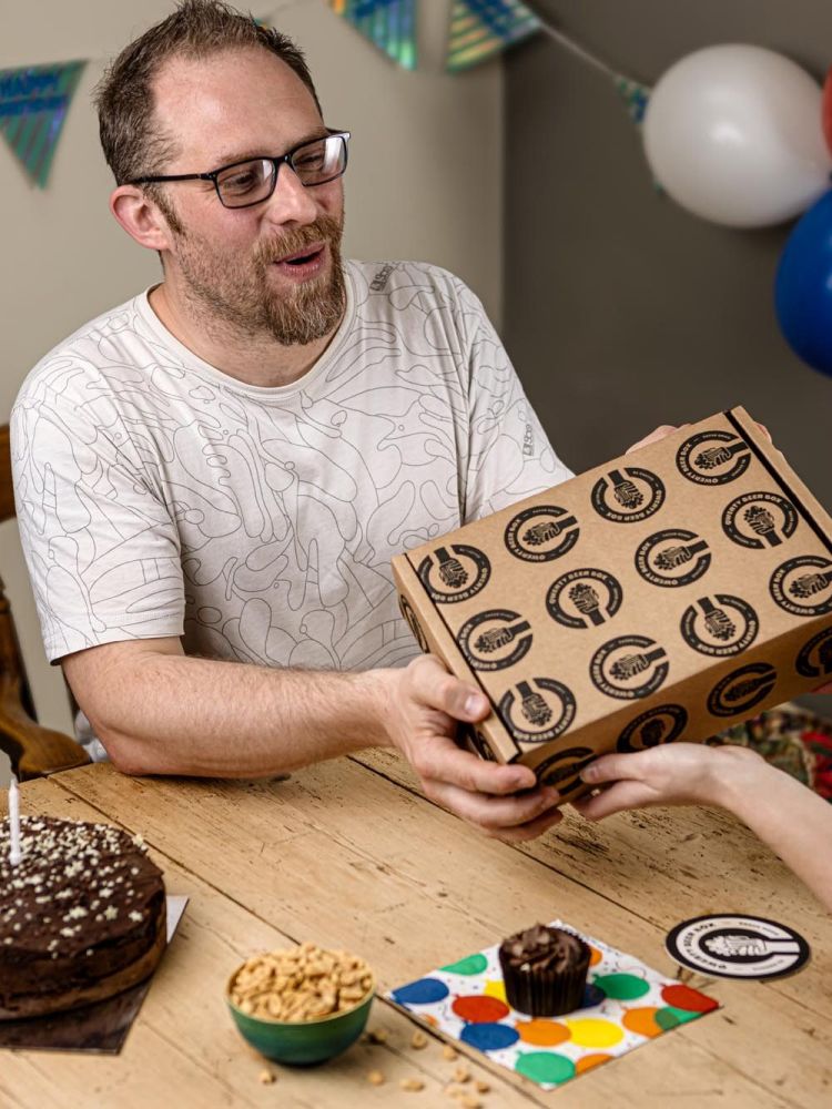 man being given a lager beer gift box for his birthday