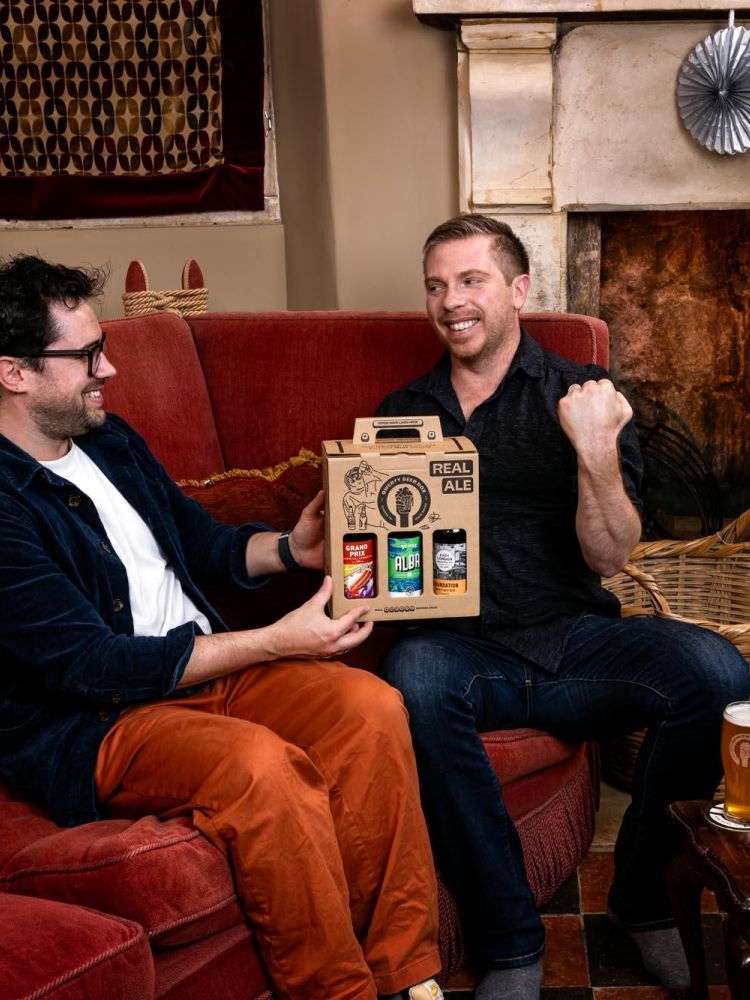 man giving friend a real ale gift box