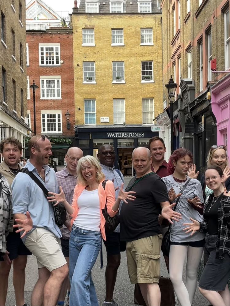 tour group posing for photo while walking london's west end