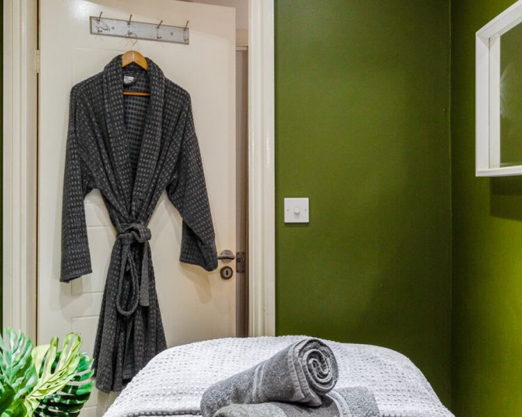 Spa treatment room with dressing gown hung on door