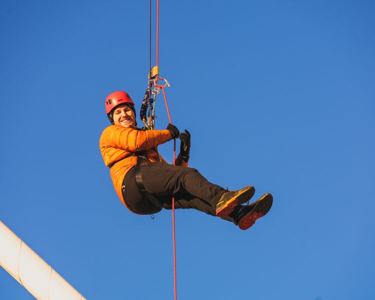 person mid-air abseiling down the principality stadium at zip world cardiff