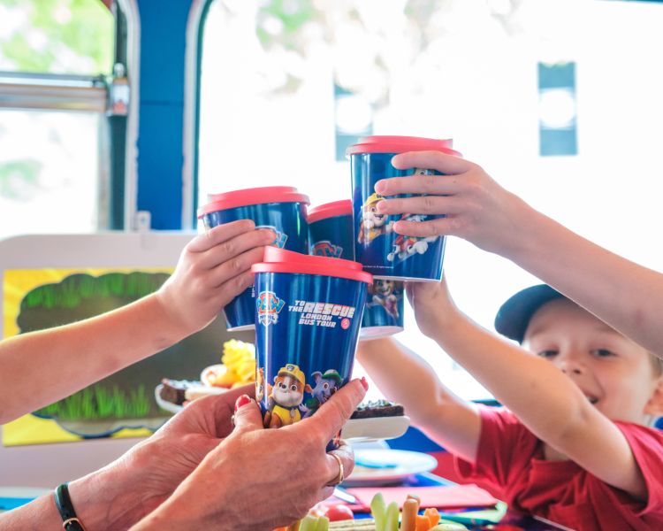 Family with souvenir cups on paw patrol afternoon tea bus tour