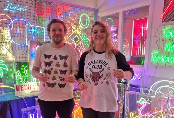 couple with their bent glass on neon sign taster session