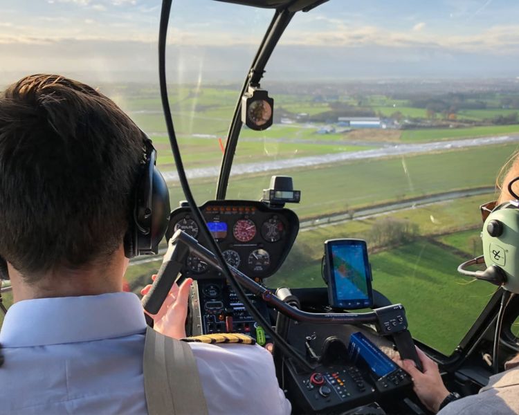 student and instructor inside the robinson r44 helicopter on a flying lesson