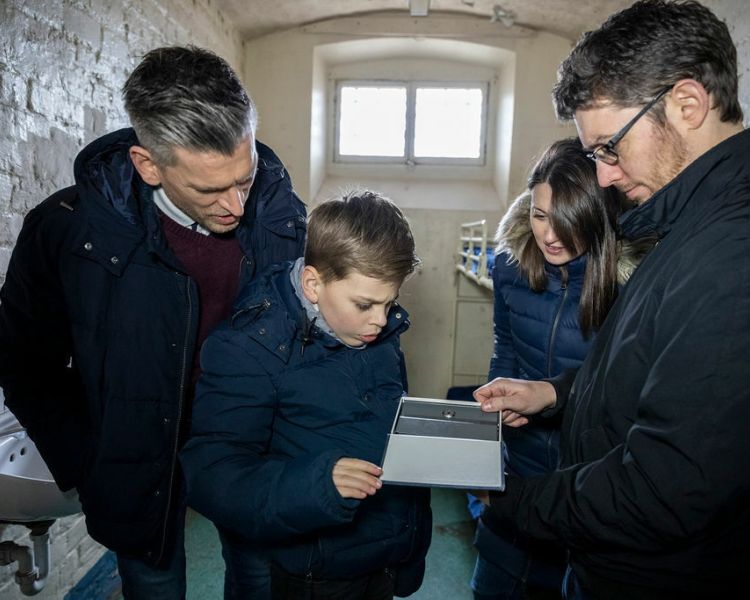 family trying to solve a puzzle as part of a prison escape room experience day