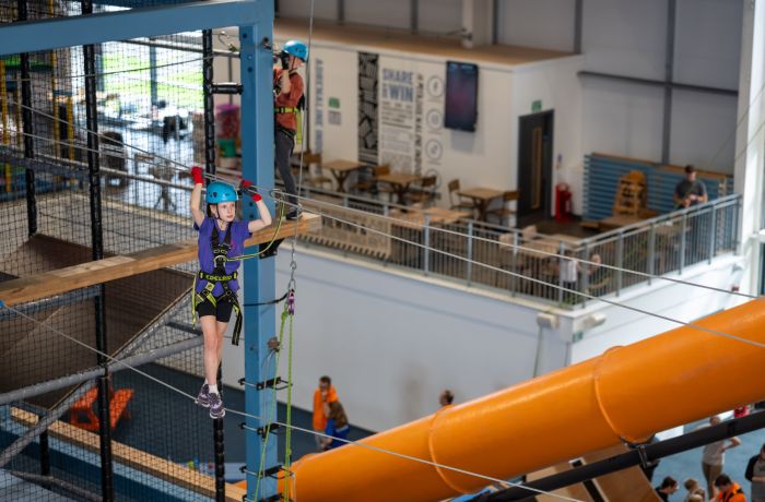 girl on indoor high ropes course at activity centre in wales
