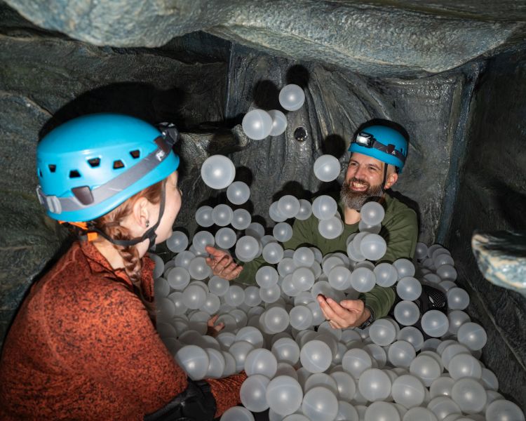 people in ball pit on indoor caving experience at activity centre in wales
