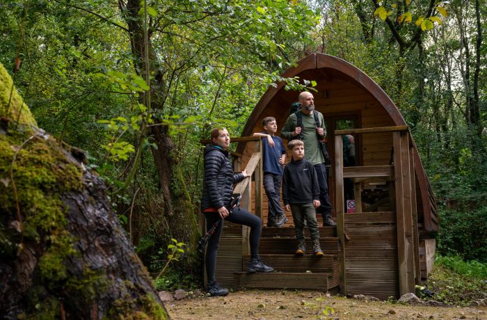 family outside a wooden pod at activity centre in wales on overnight stay