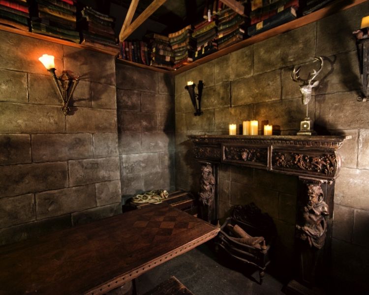 old room with wooden table in the middle and big fireplace