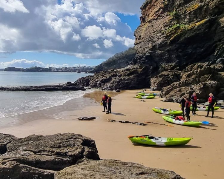 Kayakers on beach on pembrokeshire coast