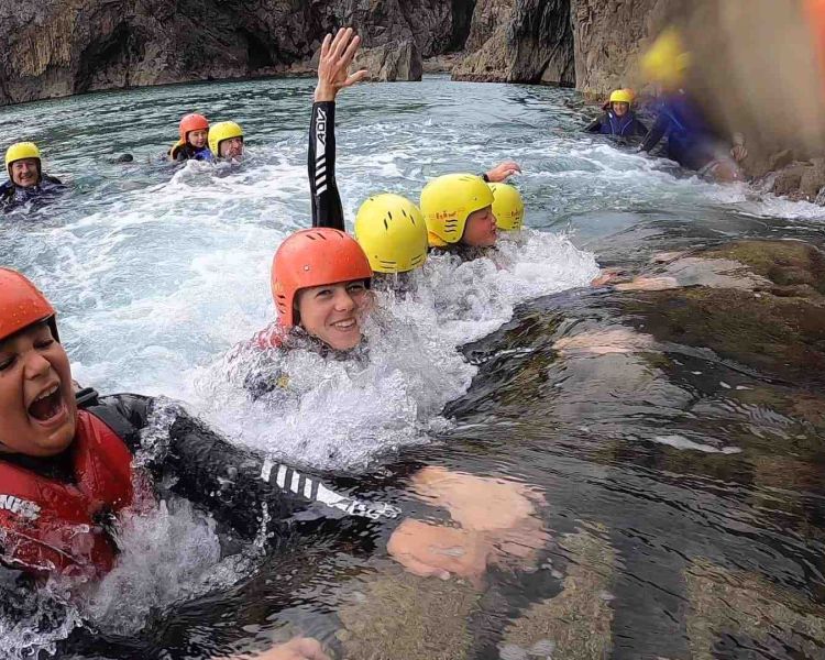 Group in water on coasteering experience in pembrokeshire