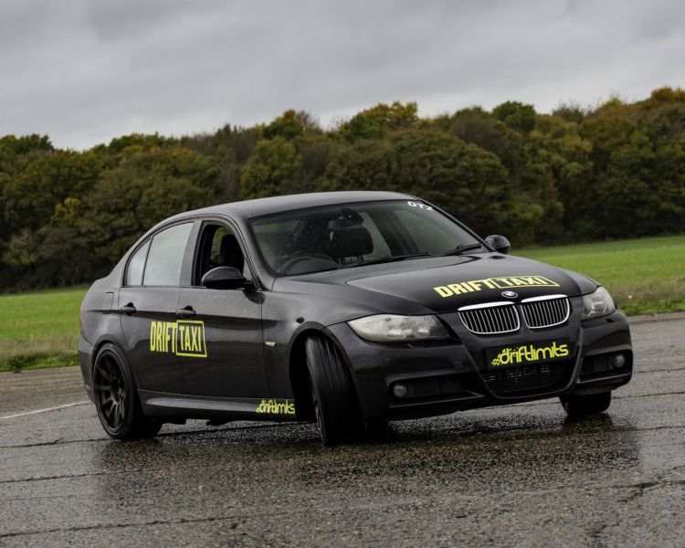 a bmw sports car on a race track as part of a drift battle driving experience