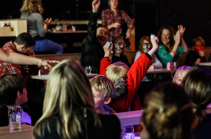 Kids with arms in air at family bingo in london