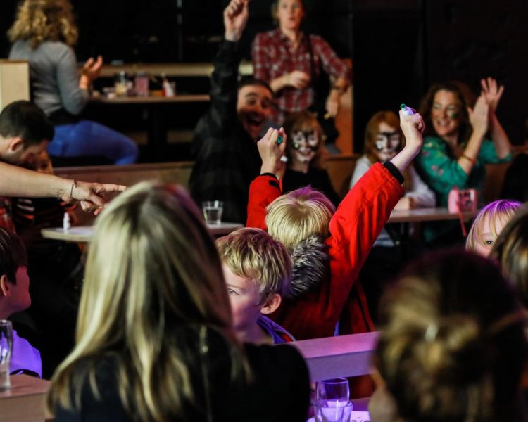 Kids with arms in air at family bingo in london