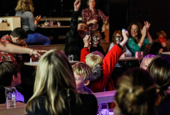 Kids with arms in air at family bingo in london