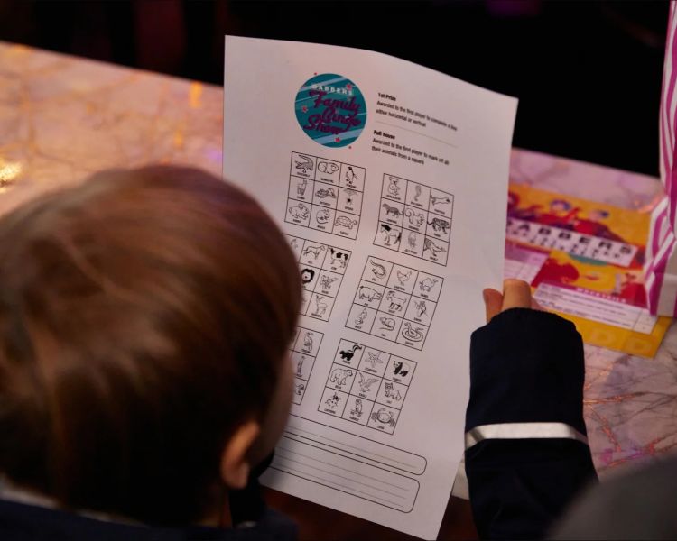 Kid looking at bingo sheet at family bingo in london