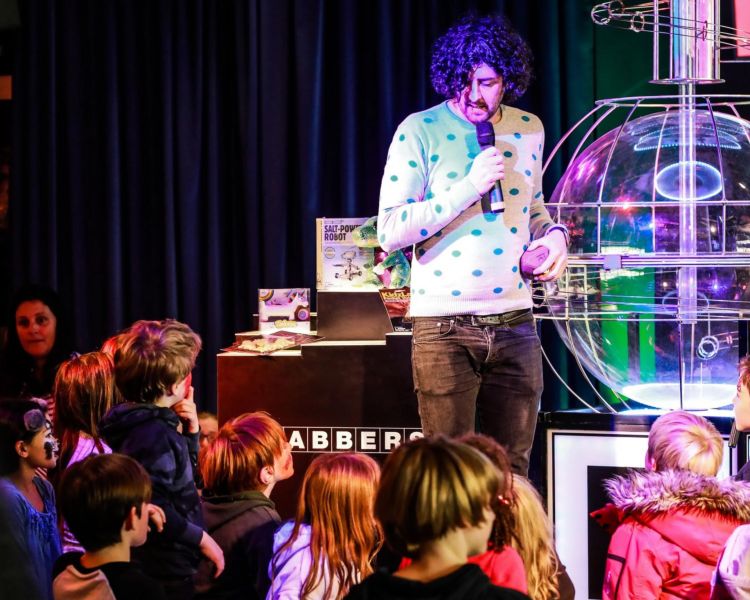 Man on stage with kids watching at family bingo in london
