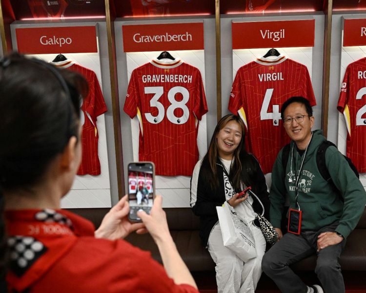 A couple posing for a photo in the liverpool fc dressing room
