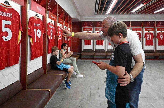 A father and son exploring the dressing room with audio guide
