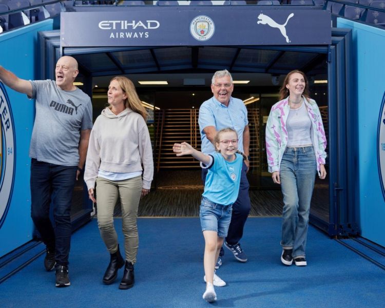 A family walking on to the pitch man city stadium