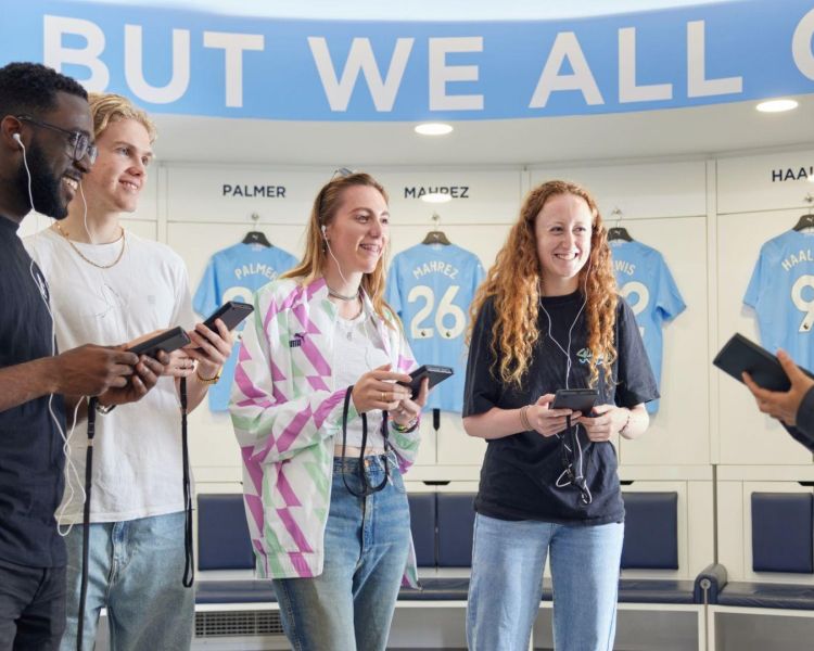 Four guests and a guide on the man city tour with audio guides