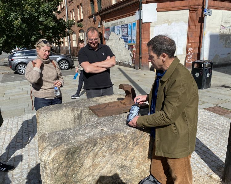 Tour guide talking to group about drink on manchester food tour
